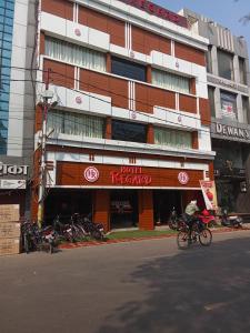 una persona montando una bicicleta delante de un edificio en Hotel Regard en Varanasi