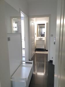 ein weißes Zimmer mit einem Waschbecken und einem Spiegel in der Unterkunft Apartment im Grünen zwischen Messe & Flughafen Köln! in Köln