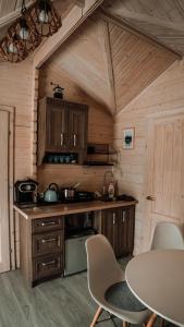 eine Küche mit einem Tisch und Stühlen in einer Hütte in der Unterkunft Mi Casa En Paczyno in Lubawka