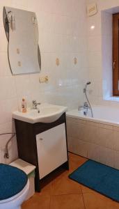 a bathroom with a sink and a tub and a toilet at Hostel Łąkowa 69 in Suwałki