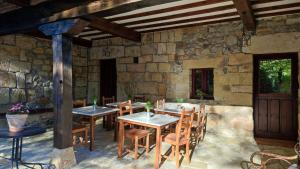 un ristorante con tavoli e sedie in un muro di pietra di Posada La Dalia a Castillo-Pedroso
