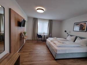 una camera d'albergo con letto e tavolo di Gästehaus und Weingut Erich Hirth a Obersulm