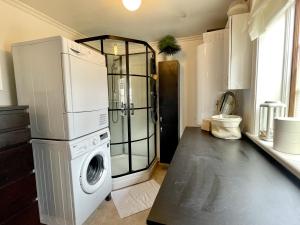 a laundry room with a washer and a shower at Pleasant accommodation with its own beach located along the Jungfrukusten in Bergby
