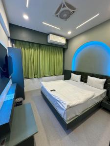 a bedroom with a bed and a flat screen tv at Hotel victoria in Surat