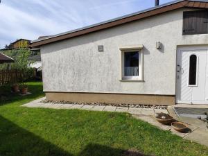 a white house with a window and a yard at Sonnengarten in Ueckeritz