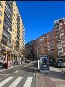 une rue urbaine vide avec de grands bâtiments et un panneau dans l'établissement Disfruta de Exclusiva habitación privada, A 5 minutos de la playa, à Vigo 6 autres photos