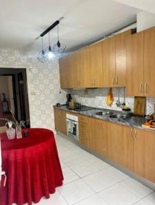 una cucina con armadi in legno e tavolo rosso di Disfruta de Exclusiva habitación privada, A 5 minutos de la playa en Vigo a Vigo