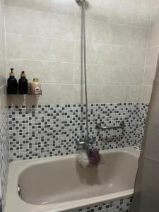 uma banheira na casa de banho com azulejos pretos e brancos em Disfruta de Exclusiva habitación privada, A 5 minutos de la playa en Vigo em Vigo