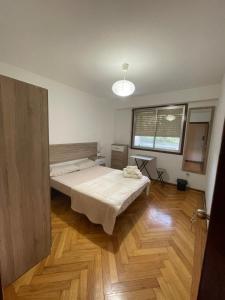 een slaapkamer met een bed en een houten vloer bij Disfruta de Exclusiva habitación privada, A 5 minutos de la playa en Vigo in Vigo