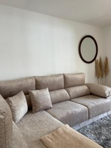 Sofá marrón en la sala de estar con espejo en Disfruta de Exclusiva habitación privada, A 5 minutos de la playa en Vigo en Vigo