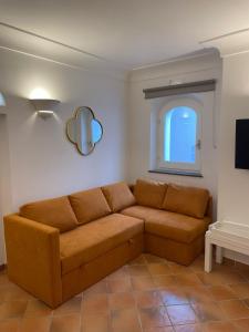 un divano marrone in un soggiorno con finestra di Casa Lucia Relaxing rooms ad Anacapri