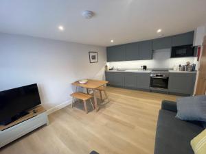 a living room with a table and a kitchen at Seasteps Padstow in Padstow