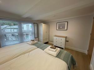 a bedroom with a large bed and a window at Seasteps Padstow in Padstow