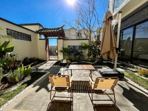un patio con mesa, sillas y sombrilla en Dalifornia Courtyard Retreat, en Dali