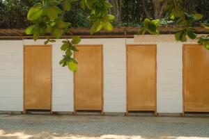 eine Reihe von Holztüren in einem weißen Gebäude in der Unterkunft Long Beach Camp in Perhentian Island
