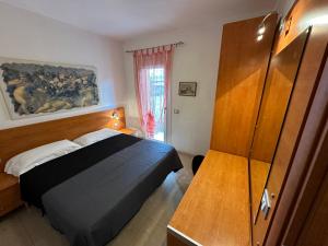 1 dormitorio con 1 cama y armario de madera en Appartamenti Levante - Agenzia Cocal, en Caorle