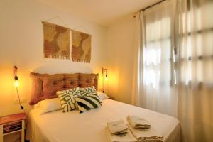 Schlafzimmer mit einem weißen Bett und einem Fenster in der Unterkunft Illes 21 in L'Estartit