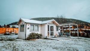 a small white house with a table and a chair at Mi Casa En Paczyno in Lubawka