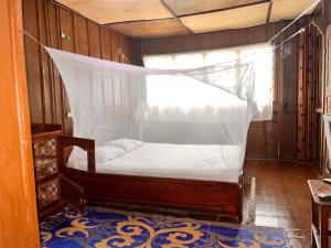 a bedroom with a bed with a mosquito net at Hotel Germain - Ganvié Holiday Resort in Ganvié
