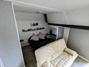 um quarto com uma cama e um sofá em Chez madame loic em Fère-Champenoise
