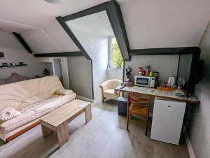 a small living room with a couch and a table at Chez madame loic in Fère-Champenoise