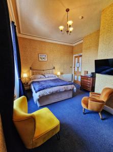 una camera con un grande letto e una sedia di The Pines Guest House a Elgin