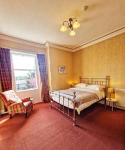 a bedroom with a bed and a chair and a window at The Pines Guest House in Elgin