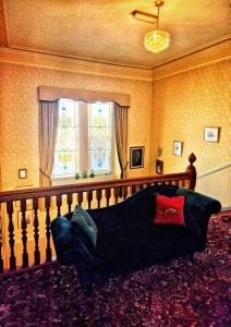 a living room with a couch in front of a window at The Pines Guest House in Elgin