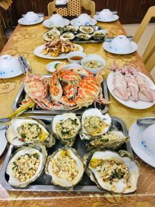 a table filled with seafood and other foods on plates at Hai Hoa Hotel in Cửa Lò
