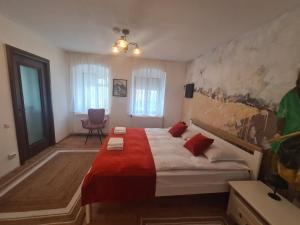 ein Schlafzimmer mit einem großen Bett mit roten Kissen in der Unterkunft ELEMENTS HAUS in Sibiu
