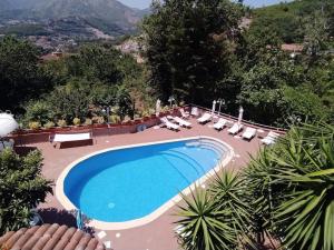 a large swimming pool with lounge chairs and a resort at Villa Elvira in Pellezzano