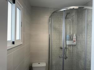 baño con ducha, aseo y ventana en Checkmate en Tolox