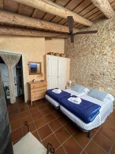 - une chambre avec un grand lit dans un mur en pierre dans l'établissement Can Bruguera de Fonteta, à Fonteta