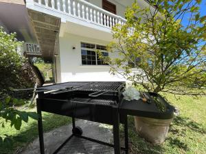 a grill in front of a house with a tree at TE REKA LODGE vue mer in Mahina