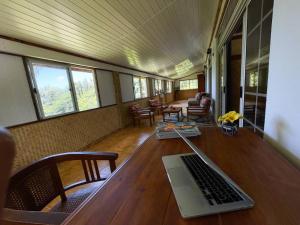 a room with a table with a laptop on it at TE REKA LODGE vue mer in Mahina