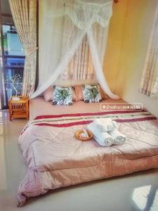 Un dormitorio con una cama con dos muñecas. en Baan Hug Na en Ban Khao Chakan