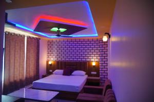 um quarto com uma cama e uma iluminação roxa em JB Hotel and Resort em Lohaghāt