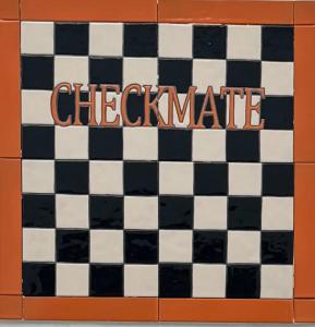un tablero de ajedrez blanco y negro con la palabra a cuadros en Checkmate en Tolox