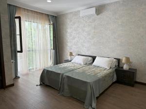 ein Schlafzimmer mit einem Bett und einem großen Fenster in der Unterkunft Three Palms Guest House in Tbilisi City