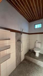 a bathroom with a toilet and a shower at Puri Pilihani Hostel in Munduk