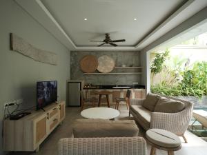 a living room with a couch and a table at Daun Lebar Villas in Payangan