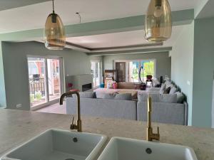 a kitchen with two sinks and a living room at Retreat Villa, 17m to Downtown, up to 29ppl in Lisbon