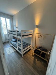 una stanza con due letti a castello e uno specchio di Belle maison médocaine a Saint-Julien-Beychevelle