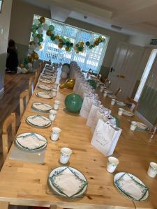 a long wooden table with plates on it at Whittonlodge sleeps26 in Hardstoft