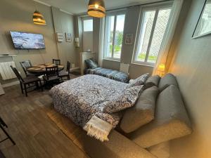 un soggiorno con un letto e un divano di Belle maison médocaine a Saint-Julien-Beychevelle