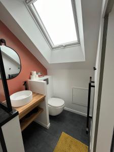 uma casa de banho com um WC branco e uma clarabóia em Chambres privées proche DISNEY Parcs em Chanteloup En Brie