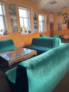 a living room with green couches and tables and windows at АРТ-ВОКЗАЛ in Kryvyi Rih