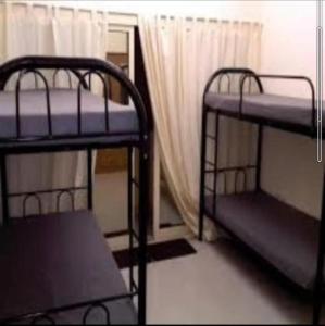 Backpackers Hostel في دبي: سريرين بطابقين في غرفة مع نافذة