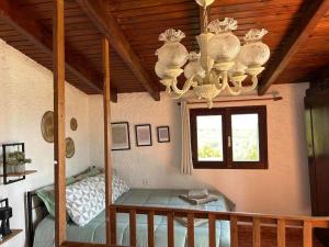 a room with a chandelier and a table and a window at Aristea's House in Arkalochori