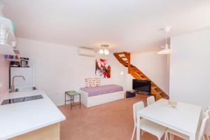 ein Wohnzimmer mit einem Bett und einer Treppe in der Unterkunft Apartment Potkova in Dubrovnik + 11 Fotos
